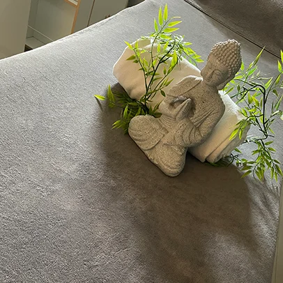 Esthéticienne souriante derrière un comptoir, présentoirs de maquillage et affiche de soin minceur.