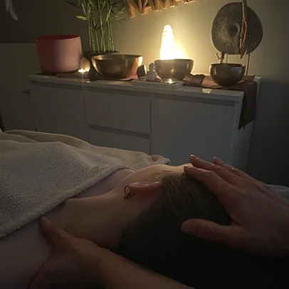 Cabine de bronzage bleue avec sol en carrelage, mur clair et miroir rond.